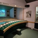 The auditorium featuring an interactive map and films playing on the screen