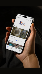 a hand holding a mobile phone with the digital guide on the screen
